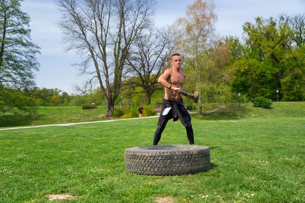 Man träning med slägga och däck — Stockfoto