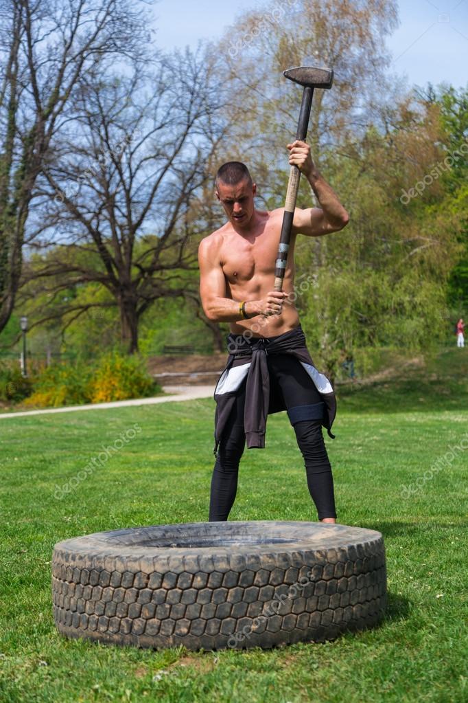 Man training with sledgehammer and tire — Stock Photo © paulprescott