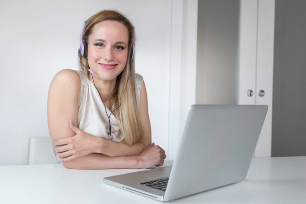 Femeia zâmbitoare care lucrează la un laptop . — Fotografie, imagine de stoc