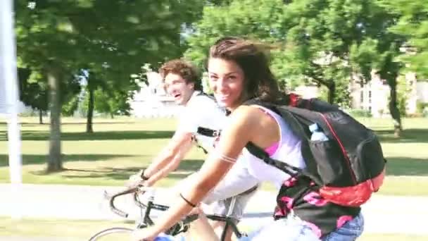 Paar genieten van fietsen in de buurt van park — Stockvideo