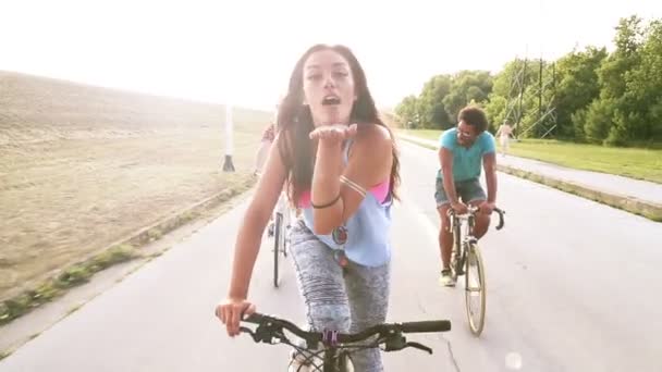 Женщина посылает поцелуи во время езды на велосипеде — стоковое видео