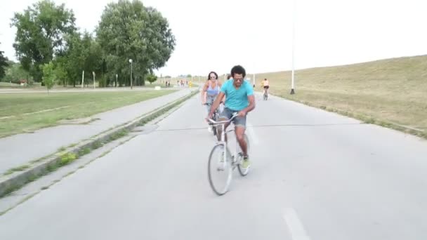 Adultos jóvenes en bicicleta al aire libre — Vídeos de Stock