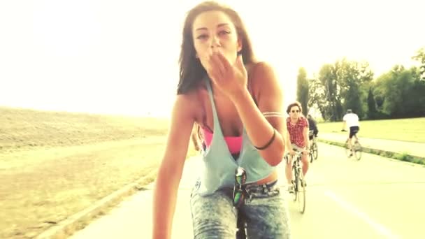 Woman sending kisses while cycling — Stock Video