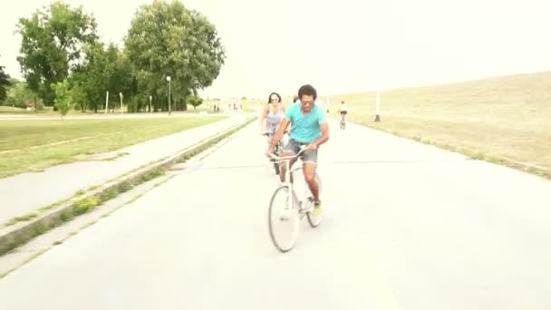 Adultos jóvenes en bicicleta al aire libre — Vídeo de stock