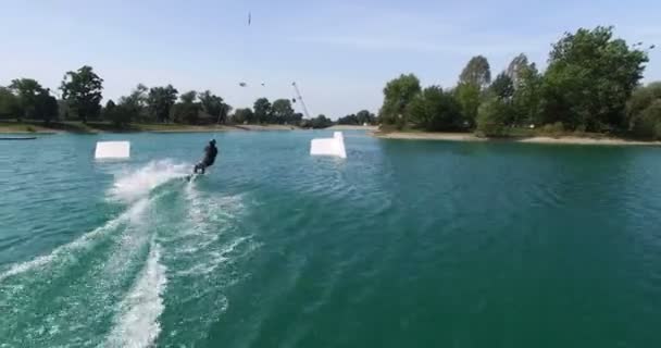 Man springt over de kicker in wake park — Stockvideo