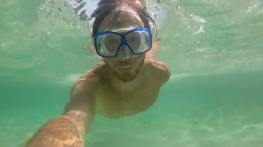 Adam suyun altında yüzüyor.