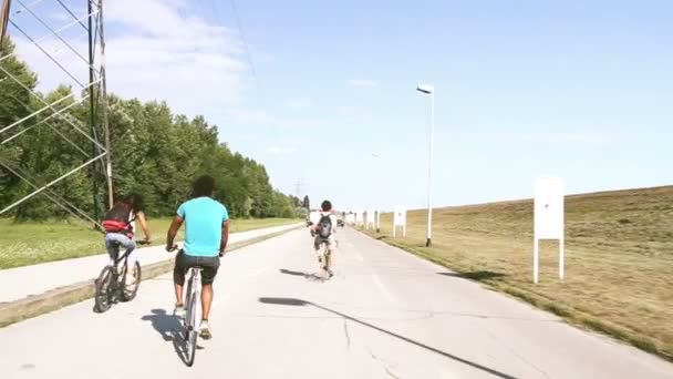 Adultos jóvenes en bicicleta al aire libre — Vídeos de Stock