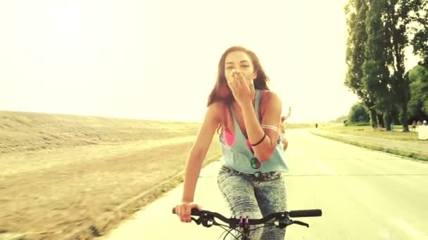 Mujer enviando besos mientras pedalea — Vídeo de stock