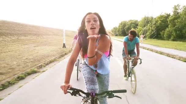Женщина посылает поцелуи во время езды на велосипеде — стоковое видео