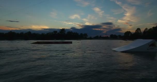 Wakeboarder salta sobre o pontapé — Vídeo de Stock