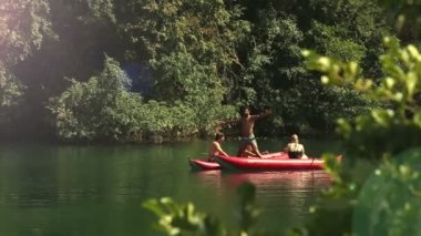 Arkadaş grubu bir Kano üzerinde duran adam