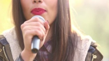 kadının ağzına şarkı mikrofon ile