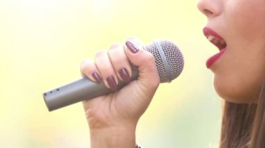 kadının ağzına şarkı mikrofon ile