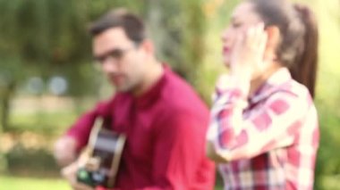 Gitar çalan ve şarkı söyleyen adam