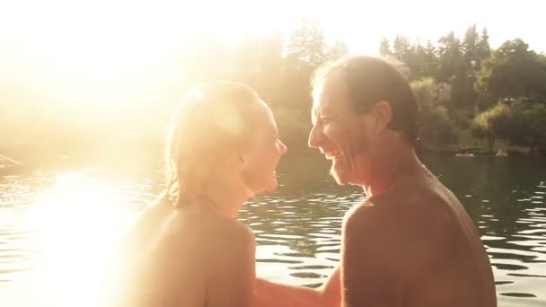 Couple assis à côté de la rivière au coucher du soleil — Video