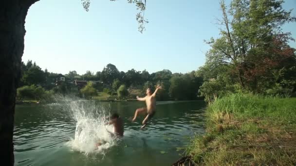 Freunde rennen und springen in Fluss — Stockvideo