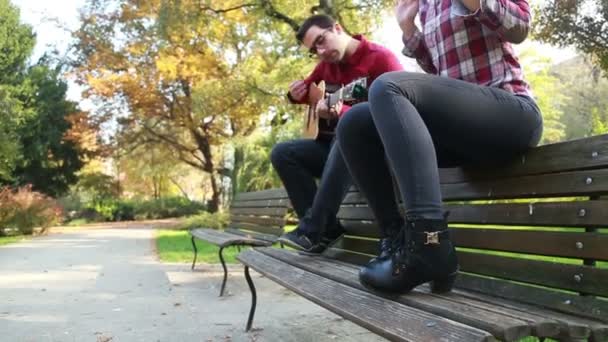 Mujer cantando mientras el hombre toca la guitarra — Vídeo de stock