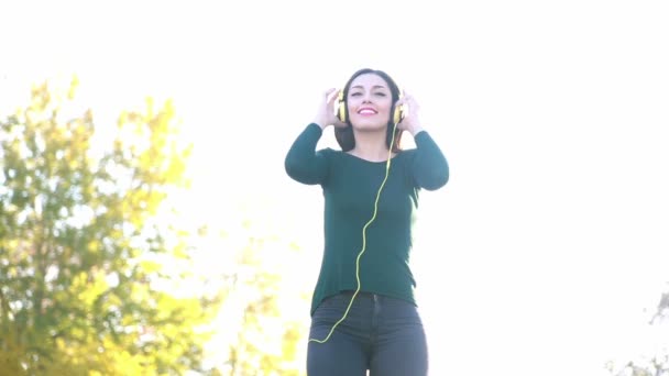 Woman putting on headphones — Stock Video