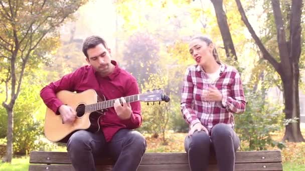 Жінка співає і чоловік грає на гітарі — стокове відео