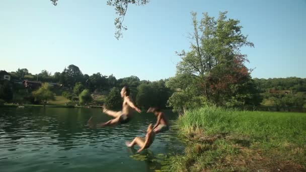 Friends running and jumping into river — Stock Video