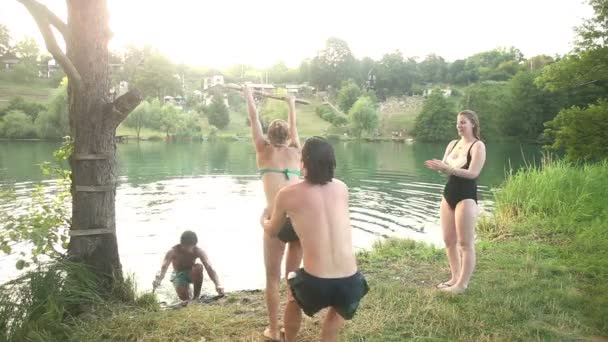 Freunde springen von Seilschaukel in Fluss — Stockvideo