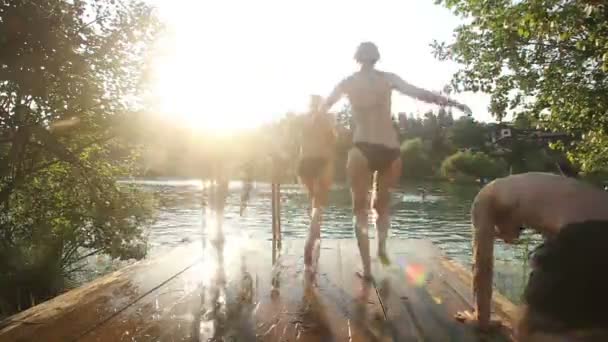 Vrienden lopen en springen in de rivier — Stockvideo