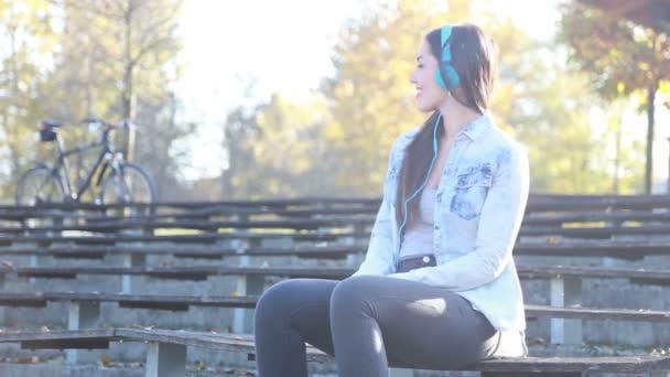 Mujer escuchando música con auriculares — Vídeos de Stock