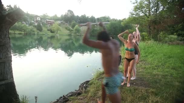 Человек, прыгающий с веревки качается в реку — стоковое видео