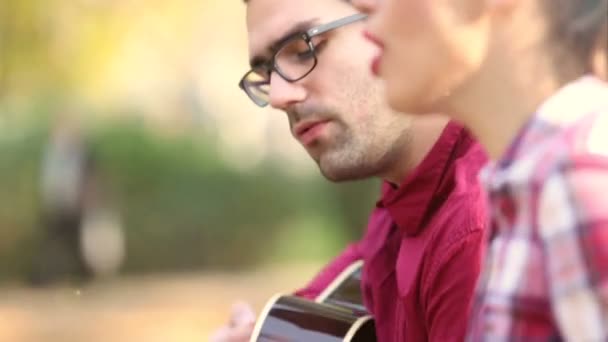 Mujer cantando mientras el hombre toca la guitarra — Vídeo de stock