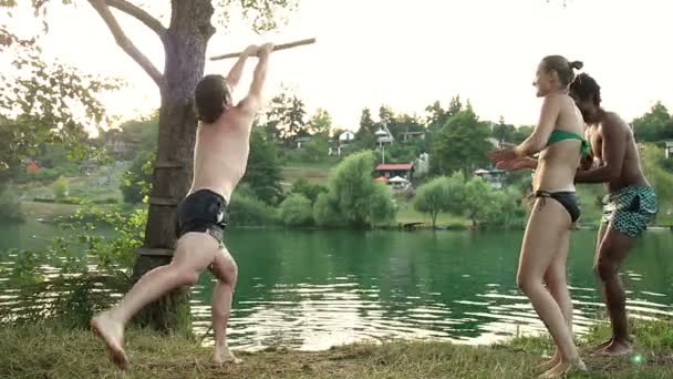 Man uit touw schommel springen in de rivier — Stockvideo