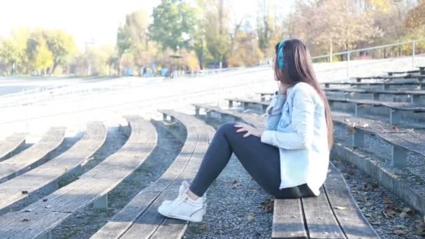 Mujer escuchando música con auriculares — Vídeos de Stock