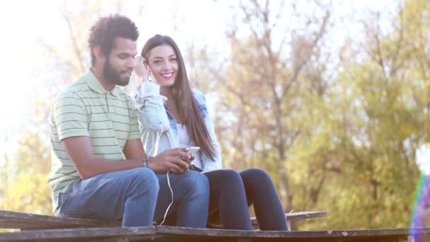 Pareja escuchando música en auriculares — Vídeos de Stock