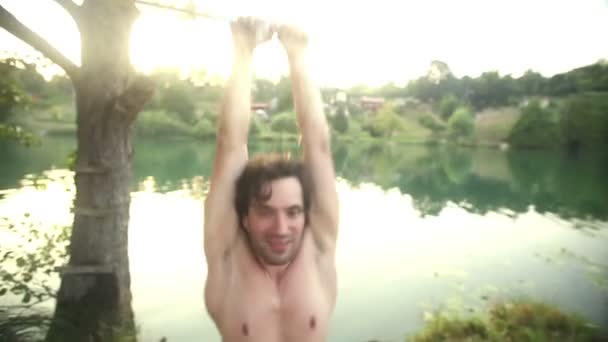 Man doing backflip off rope swing — Stock Video