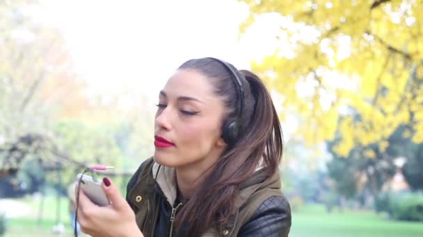 Mujer escuchando música en los auriculares — Vídeo de stock