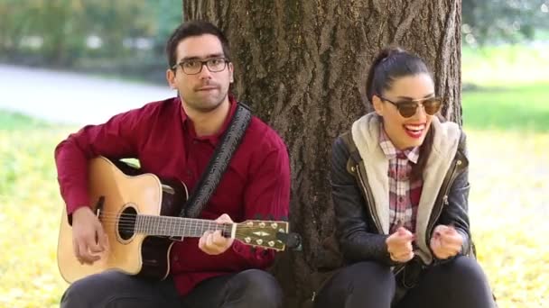 Kvinna som sjunger och man spelar gitarr — Stockvideo