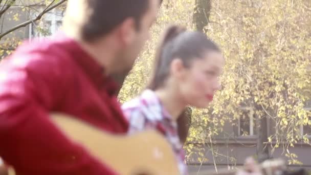 Пара поет и играет на гитаре — стоковое видео