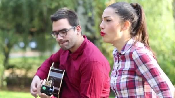 Pareja tocando la guitarra y cantando — Vídeos de Stock