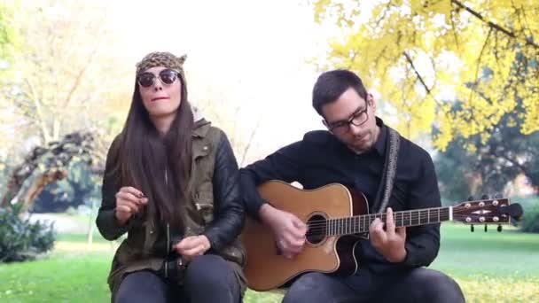 Mujer cantando mientras el hombre toca la guitarra — Vídeo de stock