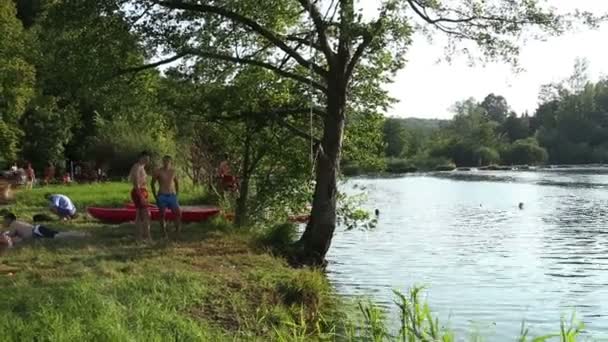 Friends running and jumping into river — Stock Video