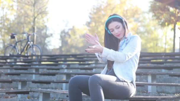 Mujer escuchando música con auriculares — Vídeos de Stock