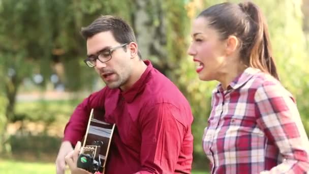 Casal tocando guitarra e cantando — Vídeo de Stock