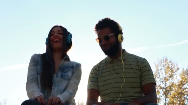 Пара слушающих музыку с наушниками — стоковое видео