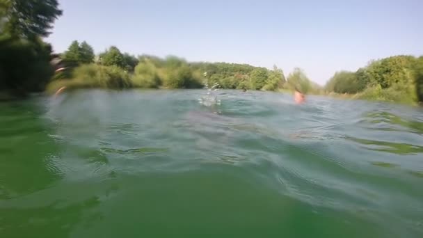 Mann schwimmt in einem Fluss — Stockvideo