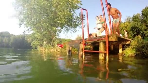 Friends running and jumping into river — Stock Video