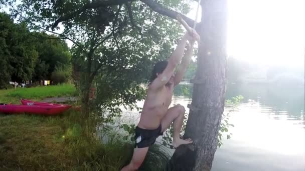 Homme sautant de swing dans la rivière — Video