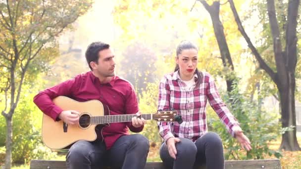 Mann spielt Gitarre, während Frau singt — Stockvideo