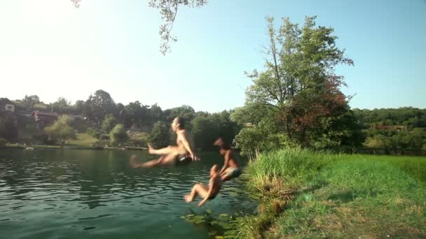 Friends running and jumping into river — Stock Video