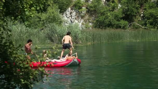 Young man jumping off canoe — Stock Video