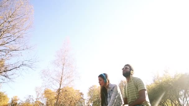 Pareja escuchando música en auriculares — Vídeo de stock