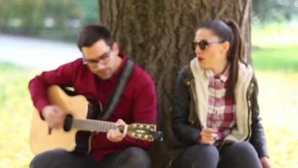 Kvinna som sjunger och man spelar gitarr — Stockvideo